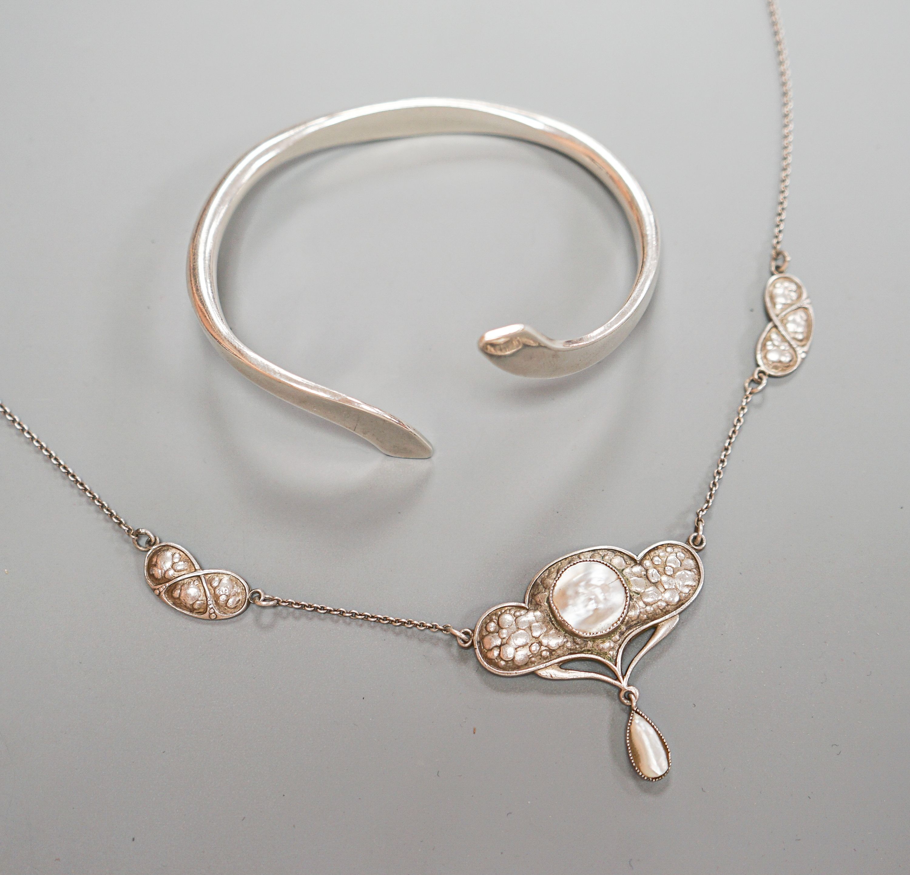 An Art Nouveau style sterling and mother of pearl set pendant necklace, stamped Queensway, 62cm and a white metal bangle.